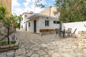 Un patio con una mesa y sillas frente a una casa. en Serenity Paxos, en Gáios