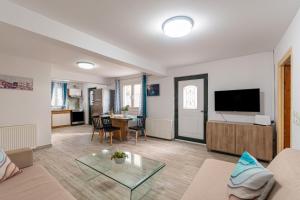 Una sala de estar con un sofá y un televisor. en Serenity Paxos, en Gáios