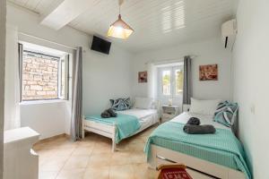Un dormitorio con dos camas y una ventana en Serenity Paxos, en Gáios