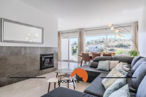 un salon avec un canapé et une cheminée dans l'établissement #339 Terras Novas N 4 By Home Holidays, à Vale da Ursa