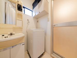a small bathroom with a sink and a refrigerator at Ikebukuro-Otsuka-10min ShinOtsuka Sta-For families and groups-Switch-net-Mobile Wi-Fi in Tokyo