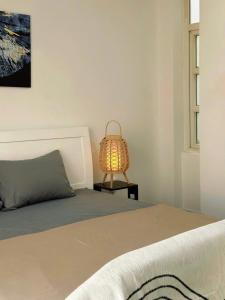 a bedroom with a bed and a lamp on a table at Homeyennii in Ho Chi Minh City