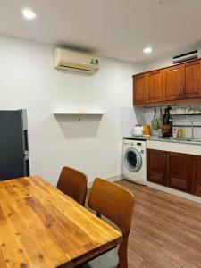 a kitchen with a wooden table and a microwave at Homeyennii in Ho Chi Minh City