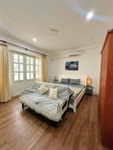 a bedroom with a large bed and a wooden floor at Homeyennii in Ho Chi Minh City +9 photos