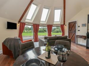 Sala de estar con mesa y botella de vino en Y Cwlwm - The Celtic Knot, en Cribyn