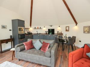 Una sala de estar con un sofá y una cocina. en Y Cwlwm - The Celtic Knot, en Cribyn
