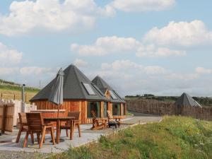 a wooden cabin with a table and chairs at Yr Awen - Inspiration in Cribyn