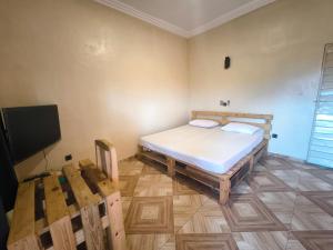 a bedroom with a bed and a flat screen tv at Tokpa Dome Appart Garden 