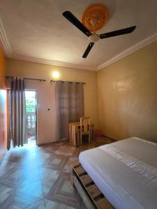 a bedroom with a ceiling fan and a table at Tokpa Dome Appart Garden 