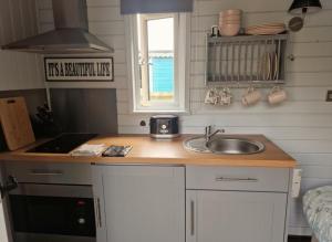 Una pequeña cocina con fregadero y ventana. en Glan yr Afon Un - Relax Recuperate Enjoy, en Welshpool