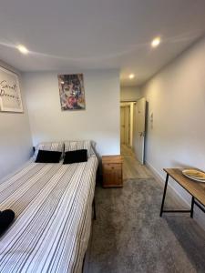 a bedroom with two beds and a wooden table at Brigstock3 in Thornton Heath +6 photos