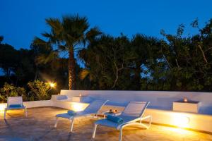 eine Terrasse mit einem Sofa und Stühlen und einer Palme in der Unterkunft El Charco in Can Furnet