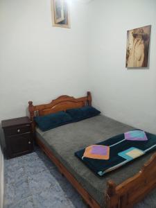 una camera con un letto in legno e una coperta di Taghazout appartement z a Taghazout