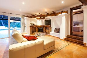 ein Wohnzimmer mit einer weißen Couch und einem Kamin in der Unterkunft El Charco in Can Furnet