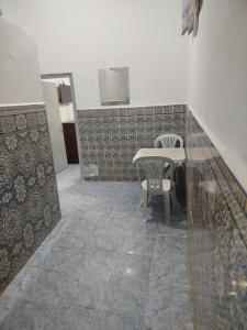 un tavolo con sedie in una stanza con pavimento piastrellato di Taghazout appartement z a Taghazout