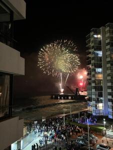 a crowd of people watching a fireworks show at night at Acogedor depto con vista al mar in Viña del Mar +5 photos