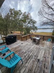 a deck with two blue chairs and a table at Keystone Direct Lake Front Cottage 2BR in Keystone Heights +27 photos