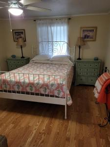 a bedroom with a bed and two dressers and a window at Keystone Direct Lake Front Cottage 2BR in Keystone Heights