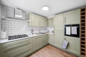 a kitchen with white cabinets and a stove at Wakefield Shakespeare - Parking Included in Wakefield