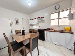 a kitchen with a wooden table and a counter top at Apartamento de 3 quartos no setor Bueno na AV T 30 proximo da Videira in Goiânia