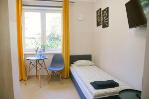 グダニスクにあるPrzystań Apartのベッドとテーブルと窓のある寝室