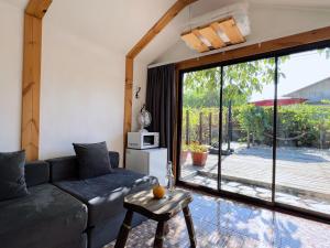a living room with a couch and a large window at Tiny House Nada Vineyard in Rakhat +18 photos
