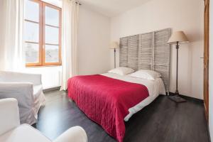 a bedroom with a large bed with a red blanket at Le Relais Des Dix Crus - Logis Hôtel in Corcelles-en-Beaujolais