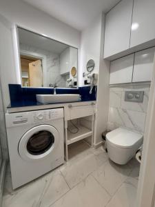 a bathroom with a sink and a washing machine at Exclusive Sea View Aparthotel In Orbi City Batumi in Batumi