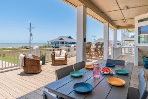 a dining table on a deck with a view of the ocean at Casa Del Sol home in Stingaree