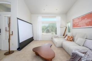 a living room with a white couch and a large screen at Echo Ridge home in Scottsdale