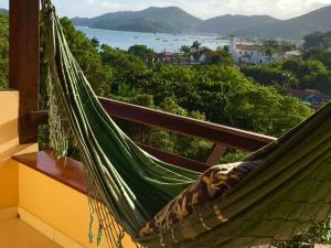 a hammock on a balcony with a view of the water at Pousada Porto Belo in Porto Belo