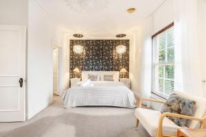 a white bedroom with a bed and a couch at Charming Red Brick Estate in Kew 5BR & Playhouse in Melbourne