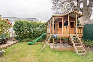 a tree house with a slide in a yard at Charming Red Brick Estate in Kew 5BR & Playhouse in Melbourne