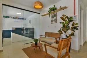 a living room with a chair and a table at Bella Catarina Bombinhas in Bombinhas
