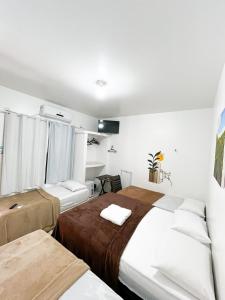 due letti in una stanza con pareti bianche di Pousada Marajó For You a Soure