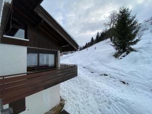 a snow covered ski slope next to a building at Aigles 19 Bajeux Bât 2 in La Clusaz