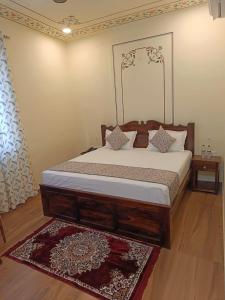 a bedroom with a bed with a wooden frame at Virasat Haveli - A Heritage Boutique Hotel in Sawāi Mādhopur