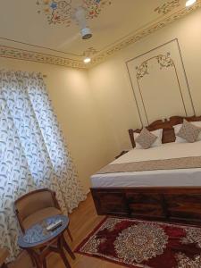 a bedroom with a bed and a chair in it at Virasat Haveli - A Heritage Boutique Hotel in Sawāi Mādhopur