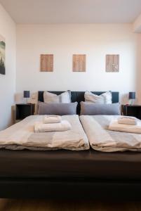 a large bed with two pillows on top of it at Corner 28 in Oberkirch