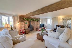 a living room with white furniture and a fireplace at Lake Cottage in Swindon