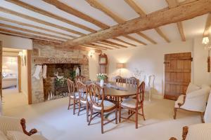 a dining room with a wooden table and chairs at Lake Cottage in Swindon