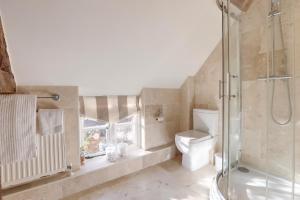 a bathroom with a toilet and a glass shower at Lake Cottage in Swindon +29 photos