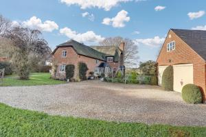 a large brick house with a white garage at Lake Cottage in Swindon
