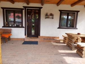 een veranda van een huis met een deur en ramen bij Cabana Mareea -Lunca Bradului in Lunca Bradului