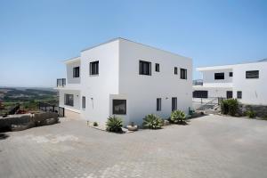 een wit huis met veel ramen bij Peace House Lourinhã in São Bartolomeu