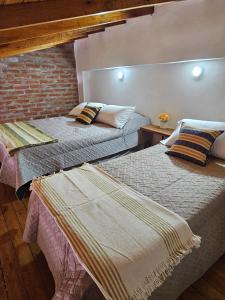 two beds sitting next to each other in a room at Casita pintoresca con entre piso in Posadas