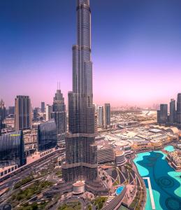 a view of a city with a tall skyscraper at GRANDE RESIDENCES with a direct Burj Khalifa view and Private Fountain Show at 62nd floor with DXB AIRPORT VIP Shuttle for 6 guests in Dubai