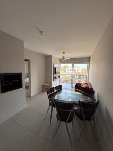 a dining room with a glass table and chairs at Ótimo apto 50m da areia churrasq 2Q 2 banheiros 301 in Torres