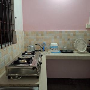 a kitchen with a stove and a counter top at Atithi Homestay in Sivasagar