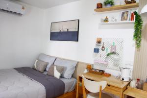 una camera da letto con un letto e una scrivania di Homeku Guesthouse Room 4 Cozy Stay Close to Suvarnabhumi Airport a Lat Krabang